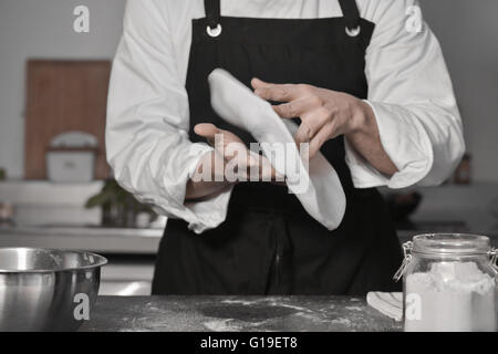 Koch Kochen Pizza in der Küche mit Händen Stockfoto