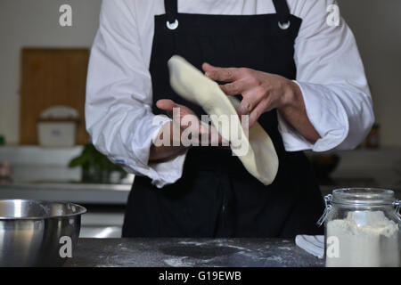 Koch Kochen Pizza in der Küche mit Händen Stockfoto