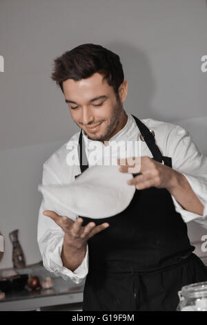 Koch Kochen Pizza in der Küche mit Händen Stockfoto