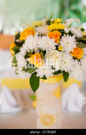 Bouquet von orange Rosen in einem weißen geflochtenen Korb und Vintage bir Stockfoto