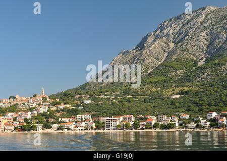 Dorf von Igrane mit Turm, Adria und hohen Berg Biokovo im Hintergrund. Makarska Riviera, Kroatien Stockfoto