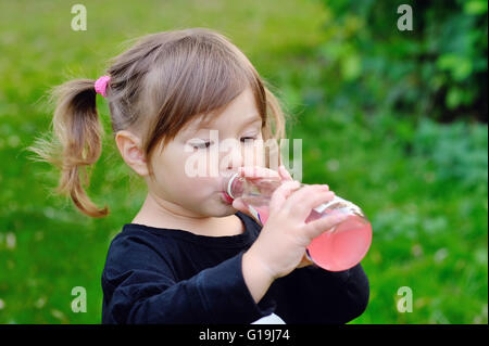 Mädchen trinken aus einer Flasche Limonade, im freien Stockfoto