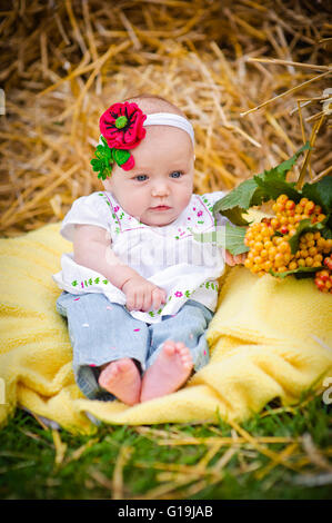 Babymädchen im Heuhaufen Stockfoto