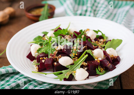 Salat von gebackenen Rüben, Rucola, Käse und Nüssen Stockfoto