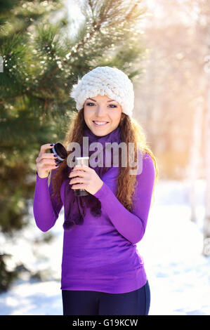 schöne junge Frau mit einer Tasse Tee in der Wintersonne Stockfoto