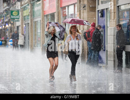 Zwei Frauen liefen eine Straße in Leicester, UK, in einen Regenschauer. Stockfoto