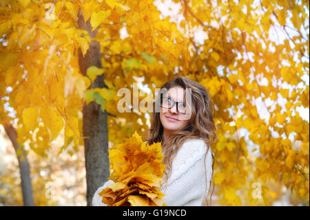Junge lächelnde Mädchen-Studentin in Gläsern schließen gegen gelbe au Stockfoto