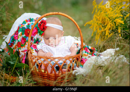 Babymädchen in einem Korb in der ukrainischen Stil Stockfoto