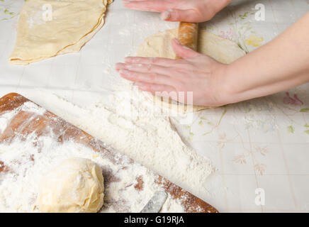 Teig machen von weiblichen Händen auf Holztisch Hintergrund Stockfoto