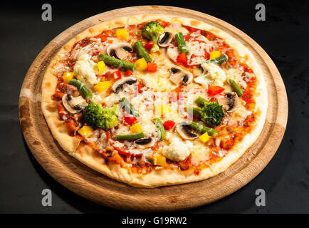 vegetarische Pizza auf einem dunklen Hintergrund mit Champignons, Käse und Paprika Stockfoto