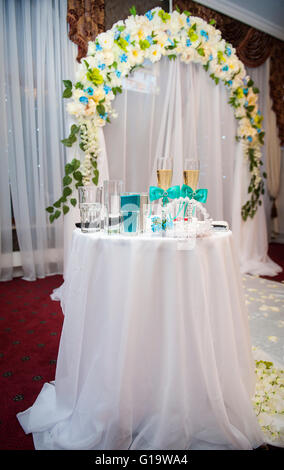 Hochzeit-Gläser auf dem Tisch vor dem Hintergrund des Bogens Stockfoto