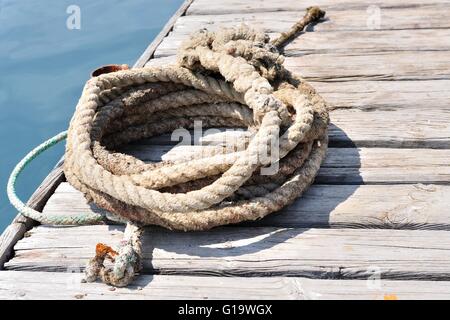 Gewickelten marine Seil auf hölzerne Pier. Podgora, Kroatien Stockfoto