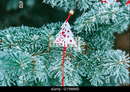 Hintergrund verschneiter Weihnachtsbaum mit roten Weihnachtsbaum Spielzeug aus Stockfoto