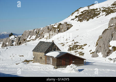 Shepherd es House auf den Schneehang in Bergen Stockfoto