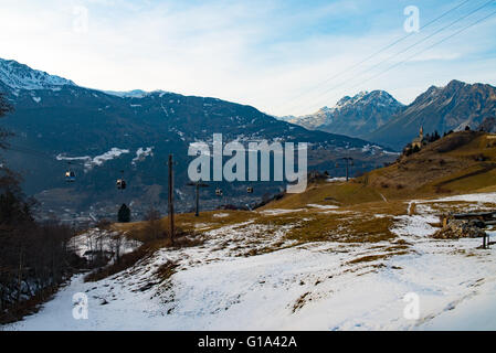 Berglandschaft mit Seilbahn, Schnee und typische Häuser Stockfoto