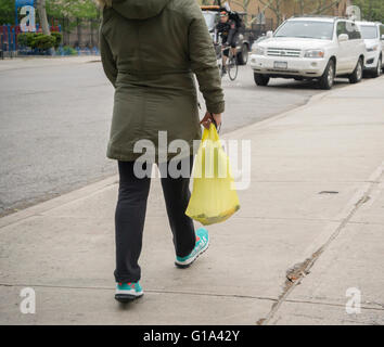 Ein Shopper mit ihrem Supermarkt-Plastiktüte am Donnerstag, 5. Mai 2016 in New York. Der New Yorker Stadtrat billigte einen Gesetzentwurf, Shopper 5 Cent für jede Tasche verwendet, um die Menschen ermutigen, wiederverwenden oder bringen Sie ihre eigenen Taschen zu berechnen. (© Richard B. Levine) Stockfoto