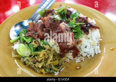 Thai style geschmortes Schweinefleisch Reis mit eingelegtem Gemüse Stockfoto