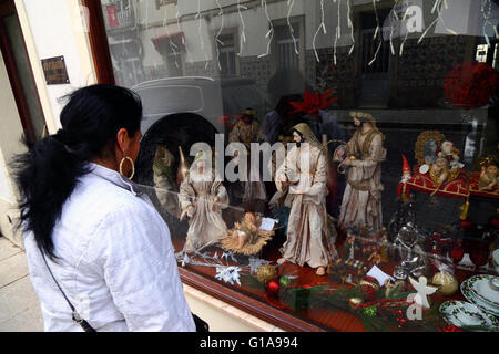 Mädchen auf der Suche bei Anzeige der Krippe Figuren im Schaufenster, Vila Praia de Ancora, Provinz Minho, Nordportugal Stockfoto