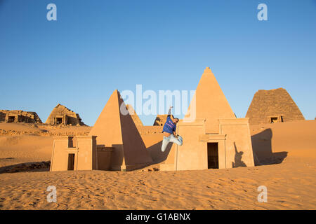 ein junger Mann springt vor auf Meroe-Pyramiden im Sudan Stockfoto