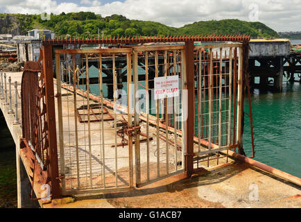 Rusty Tore und Zäune rund um eine gefährliche Struktur - eine alte verlassene Mole im Hafen von Brixham. Stockfoto