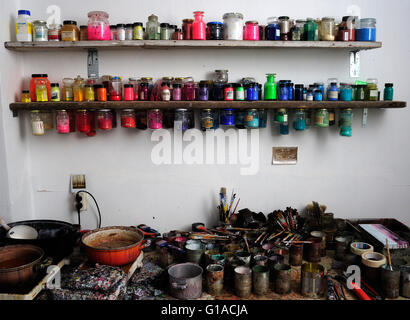 Werkbank im Künstler-Atelier mit allen Arten von Pigmenten und Dosen Stockfoto