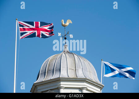 Union Jack und schottische Andreaskreuz Fahnen nebeneinander über das Rathaus von Kelso in der schottischen Grenzen UK Stockfoto