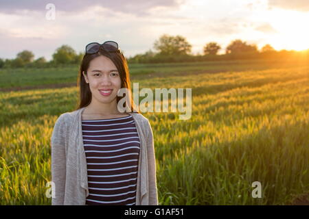 Junge glückliche Frau in einem Feld von Weizen Stockfoto