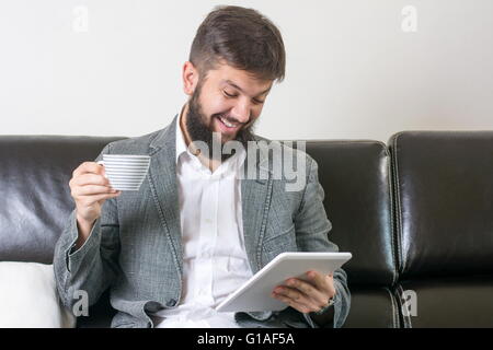 Geschäftsmann, lesen Nachrichten mit einer Tasse Kaffee Stockfoto