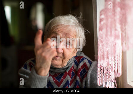 Ältere Frau droht mit einem Finger in die Kamera schaut. Stockfoto