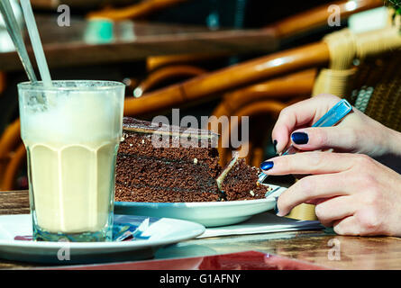 Eine Frau an einem sonnigen Nachmittag Kaffee und leckeren Kuchen genießen Stockfoto