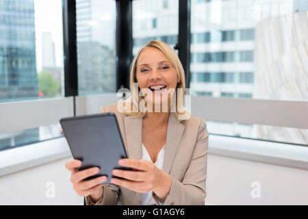 Glücklich applying Geschäftsfrau mit digital-Tablette. Moderne Office-Hintergrund Stockfoto
