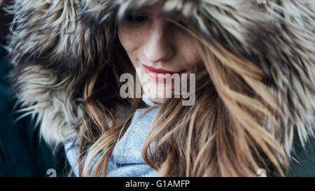 Junge lächelnde Frau mit Fell Kapuze, Mode und Winter-Konzept Stockfoto