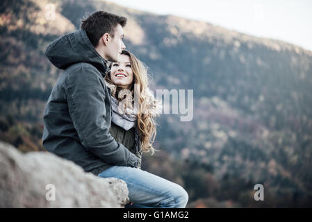 Romantische junges Paar im Winter aus, sie sitzen zusammen, sie sucht bei ihrem Freund Stockfoto