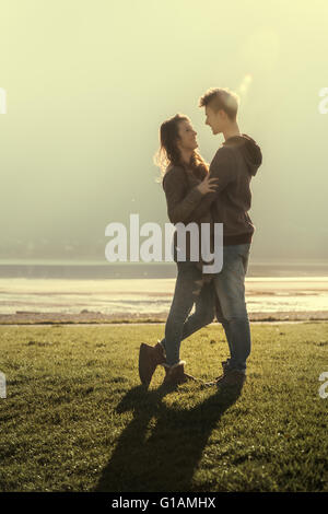 Glücklich Romantisches Liebespaar am See umarmt und starrte auf jedes andere, Liebe und Beziehungen-Konzept Stockfoto