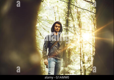 Junger Mann zu Fuß in den Wald umrahmt von Bäumen