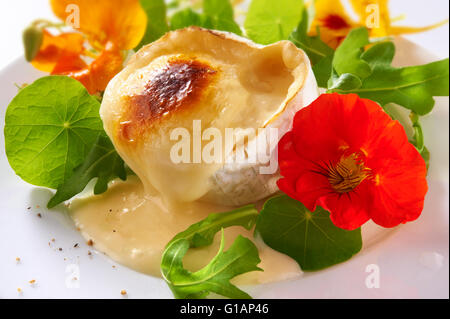 Grillefd geschmolzener Ziegenkäse mit frischen Kapuzinerkresse blüht & Blätter Salat Stockfoto