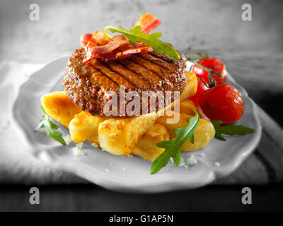 Char, gegrilltes Rindfleischburger oder Hamburger und Speck mit klobigen Pommes Frites und Salat Stockfoto