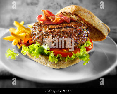 Beef-Burger oder Hamburger in einem mit Vollkorn Brötchen mit Pommes frites Stockfoto