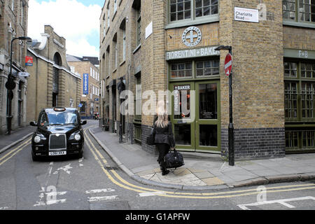 Black Cab und Frauen mit Taschen außen FIORENTINI+BAKER Stiefel shop in Charlotte Road Shoreditch East London UK KATHY DEWITT Stockfoto
