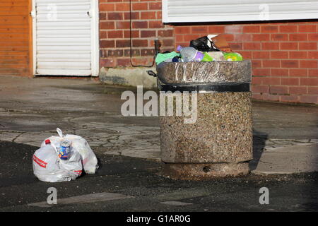 Bin in einer Seitenstraße in einem Vorort von Stockport - Müll über fließenden öffentlichen volle Säcke mit Müll neben den Mülleimer Links sind Stockfoto