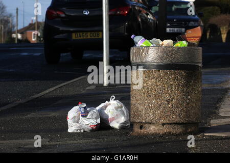 Bin in einer Seitenstraße in einem Vorort von Stockport - Müll über fließenden öffentlichen volle Säcke mit Müll neben den Mülleimer Links sind Stockfoto