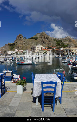 Restaurant Tische mit blauen sitzen, mit Blick auf die byzantinische Festung Teil der landschaftlich reizvollen Myrina Landschaft. Lemnos oder Limnos, Griechenland Stockfoto