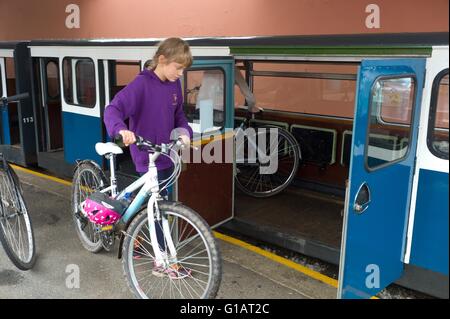 Ein Teenager Kind, ihr Fahrrad auf die Ravenglass Eskdale Railway in Ravenglass Station Cumbria Stockfoto