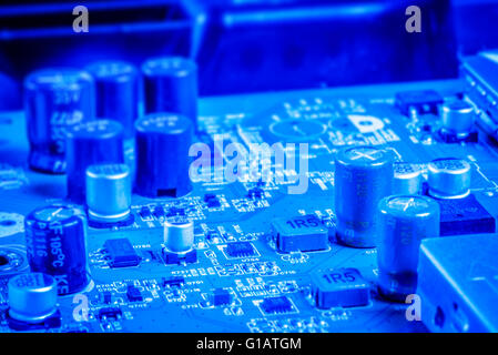 Elektronische Kondensatoren und Chips auf eine Mikroplatine in blauer Farbe Stockfoto