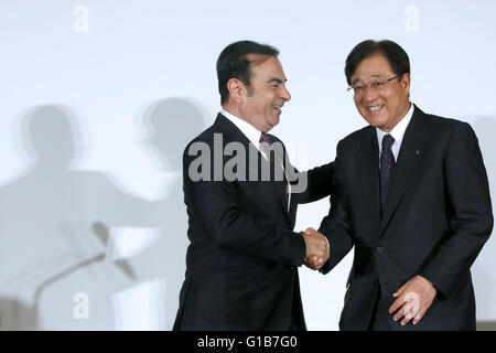 Tokio, Japan. 12. Mai 2016. Nissan Motor Corp CEO Carlos Ghosn streichelt den Rücken von Mitsubishi Motors Corp. Chairman und Chief Executive Officer Osamu Masuko nach einer Pressekonferenz in Yokohama, südlich von Tokio, Japan, 12. Mai 2016. © Takeshi Sumikura/AFLO/Alamy Live-Nachrichten Stockfoto