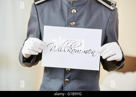 An der Rezeption halten deutsche Schild mit der Aufschrift "Willkommen" (willkommen) Stockfoto