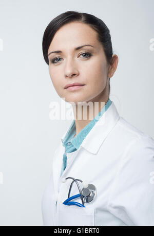 Lächelt zuversichtlich Ärztin Portrait mit Kittel und Stethoskop. Stockfoto