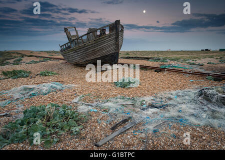 Und altes Boot umgeben von Schutt und Fischerei Netze, Dungeness, Kent. Stockfoto