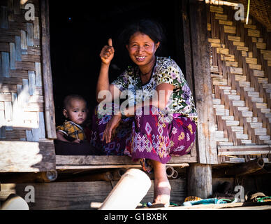 Eine Dame und ein Baby am Eingang zu ihrem Bambushaus in Pankam Dorf in der Nähe von Hsipaw Stockfoto