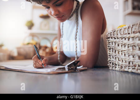 Bild des jungen Afrikanerin arbeiten in eine Saftbar beschnitten. Frau hinter der Theke stehen und Schreiben von Notizen. Berechnung einer Stockfoto